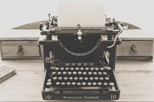 An antique typewriter sits on a writing desk
